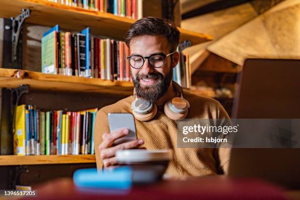 male professor using mobile phone in the office - male at home imagens e fotografias de stock