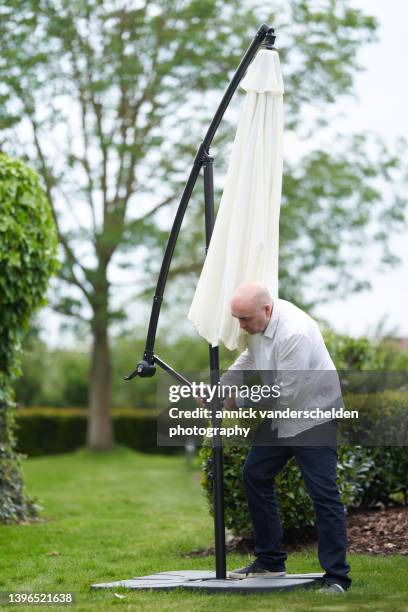 patio umbrella height adjustment - putting sunscreen stock pictures, royalty-free photos & images