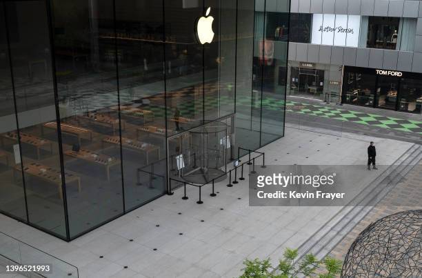 Security guard stands in front of the closed China flagship Apple Store in the usually bustling Taikoo Li mall after many retail stores were closed...