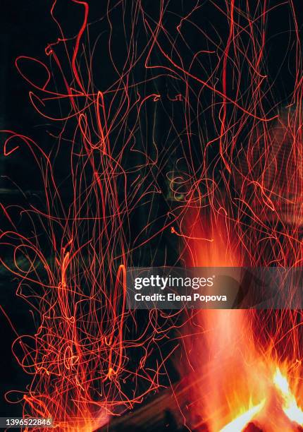 campfire flame and red sparks against dark background - campfire background stock pictures, royalty-free photos & images