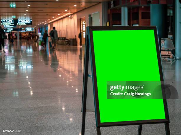 large to medium size a frame green screen chroma key marketing advertisement billboard in city centre shopping mall, train bus station or airport environment targeting adverts at consumers, retail shoppers, commuters and tourists. - sign board stock-fotos und bilder