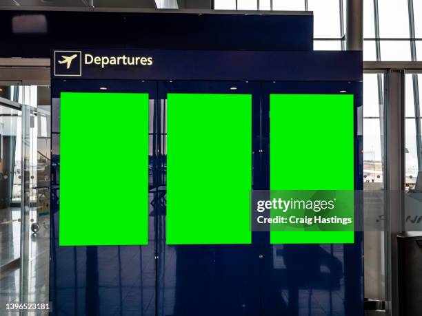 3 large to medium size departure green screen chroma key marketing advertisement billboard in city centre shopping mall, train bus station or airport environment targeting adverts at consumers, retail shoppers, commuters and tourists. - holiday advertising slogans fotografías e imágenes de stock