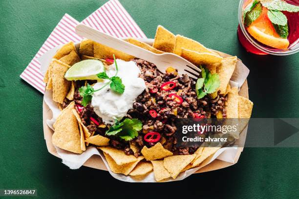 mexican traditional nacho chips with minched meat and sour sauce in a plate - sour cream stock pictures, royalty-free photos & images