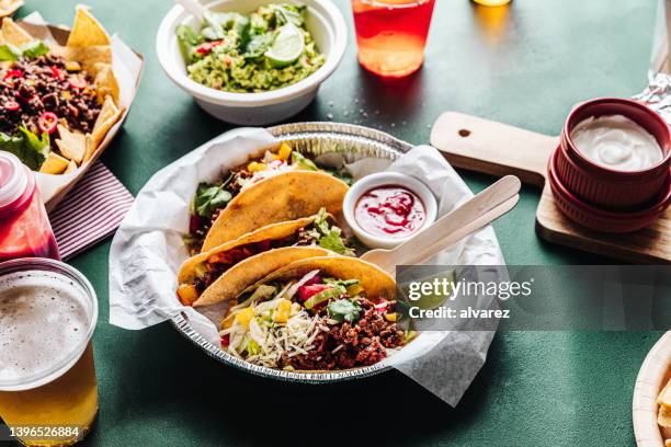 mexican tacos served with tomato sauce and beer - chili con carne stock pictures, royalty-free photos & images