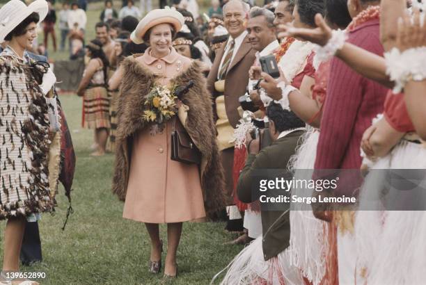Queen Elizabeth II wearing a Maori fur cape during her visit to New Zealand, 1977.