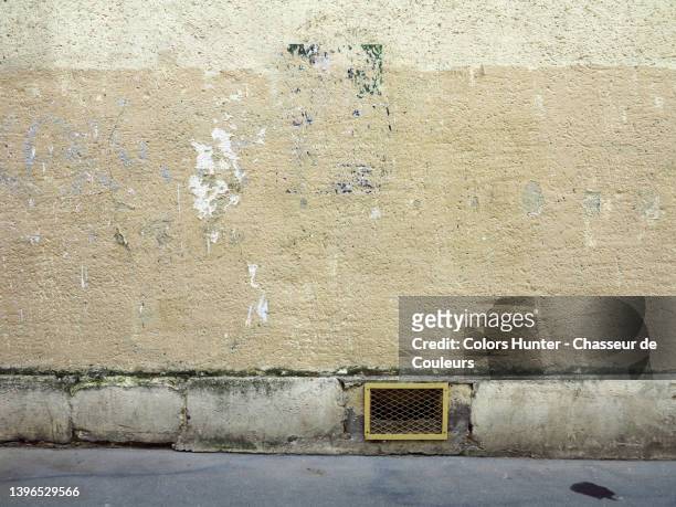 empty painted and weathered concrete wall with sidewalk and ventilation grille in paris - wall foto e immagini stock