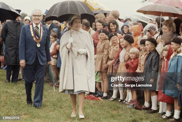 Queen Elizabeth II braves the rain during her visit to New Zealand, 1977.