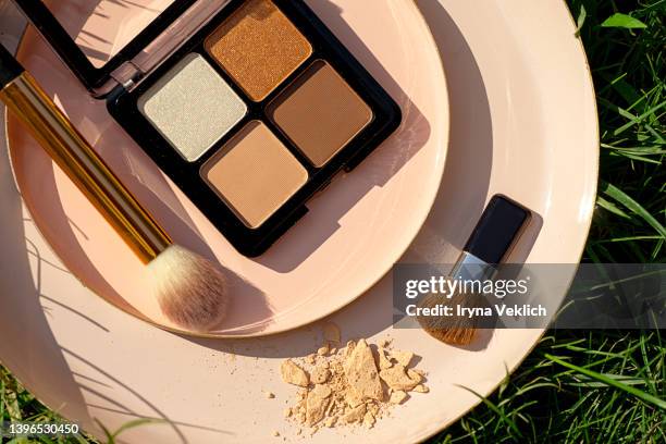makeup eyeshadows on green grass background. - oogschaduw stockfoto's en -beelden