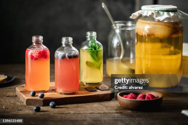 aromatisierte kombucha-teeflaschen in der küche - saft stock-fotos und bilder