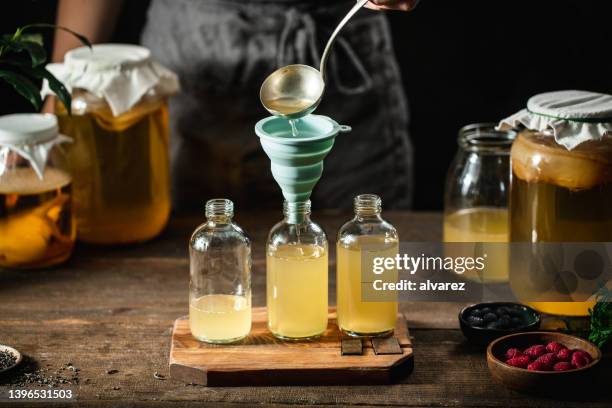 closeup of a woman preparing healthy kombucha tea - kombucha stockfoto's en -beelden