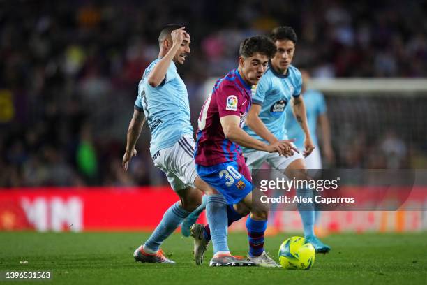 Gavi of FC Barcelona is challenged by Thiago Galhardo of Celta Vigo during the La Liga Santander match between FC Barcelona and RC Celta de Vigo at...