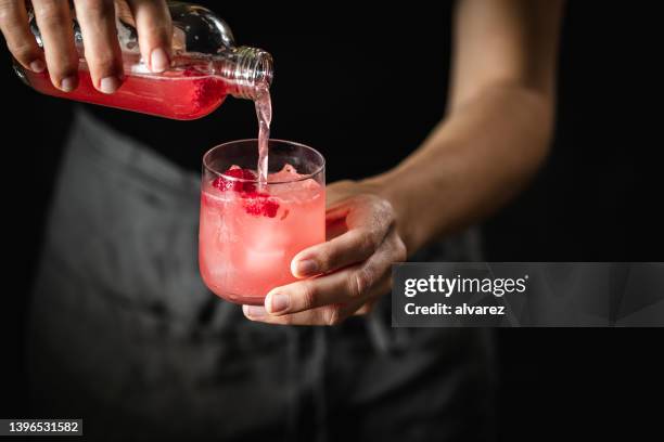 woman pouring raspberry kombucha tea in glass - kombucha stock pictures, royalty-free photos & images