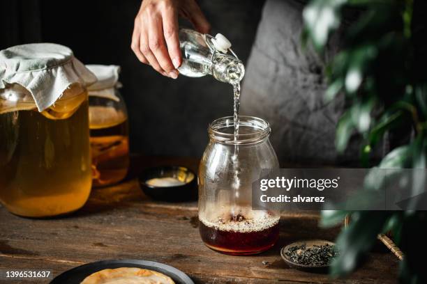 woman making healthy probiotic drink at home - kombucha stock pictures, royalty-free photos & images