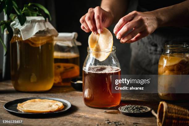 close-up of woman making kombucha at home - kombucha stockfoto's en -beelden