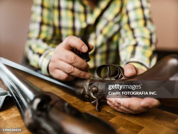 mature latin man cleaning his hunting guns - guns glory stock pictures, royalty-free photos & images