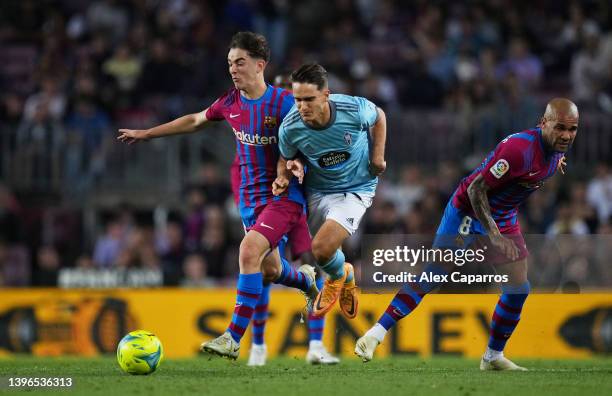 Denis Suarez of RC Celta de Vigo is challenged by Dani Alves and Gavi of FC Barcelona during the La Liga Santander match between FC Barcelona and RC...