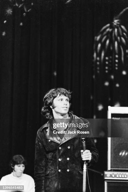 American Rock singer Jim Morrison , of the group the Doors, performs onstage at Town Hall, Philadelphia, Pennsylvania, June 18, 1967. Visible in the...