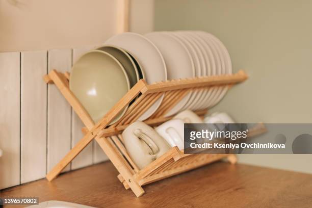 plates in a stand on the kitchen table. wooden stand for clean dishes. kitchen appliances - keep bildbanksfoton och bilder