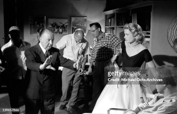 Director Alfred Hitchcock plans a shot with his crew and actress Grace Kelly on the set of the Paramount Pictures movie 'Rear Window' in November...