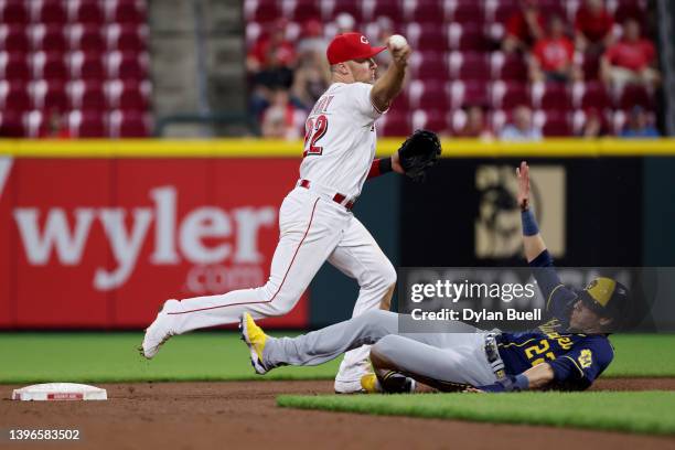 Brandon Drury of the Cincinnati Reds turns a double play past Christian Yelich of the Milwaukee Brewers in the seventh inning at Great American Ball...