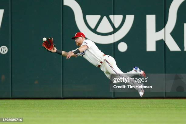 Kole Calhoun of the Texas Rangers makes a diving catch against the Kansas City Royals in the ninth inning at Globe Life Field on May 10, 2022 in...