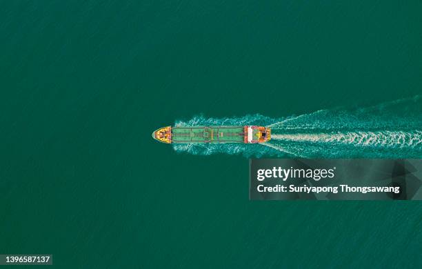 aerial top view oil ship tanker full speed with beautiful wave pattern carrier oil for transportation from refinery on the sea. - gas truck stock-fotos und bilder