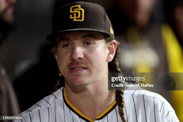 Mike Clevinger of the San Diego Padres looks on from the dugout after being pulled from the game during the fourth inning of a game against the...