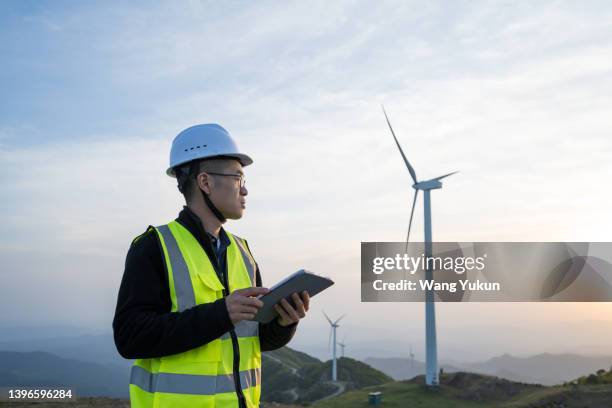 electrician using ipad at wind farm - carbon neutrality stock pictures, royalty-free photos & images