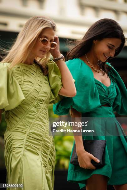 Rey Vakili wearing green mini Aje dress and black leather ankle boots and Kate Waterhouse wearing green maxi Aje dress and pink Louis Vuitton clutch...