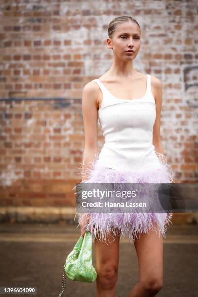 Guest wearing a white corset top and feather lavender mini skirt at Afterpay Australian Fashion Week 2022 on May 11, 2022 in Sydney, Australia.