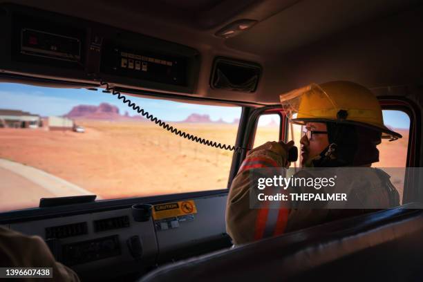 firefighter using the fire engine radio responding to an emergency call - walkie talkie stock pictures, royalty-free photos & images