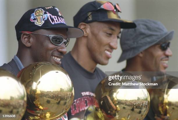 Guard Michael Jordan, forward Scottie Pippen and forward Dennis Rodman of the Chicago Bulls look at their trophies during the Chicago Bulls Victory...