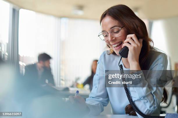 business call - woman talking on landline phone stock pictures, royalty-free photos & images