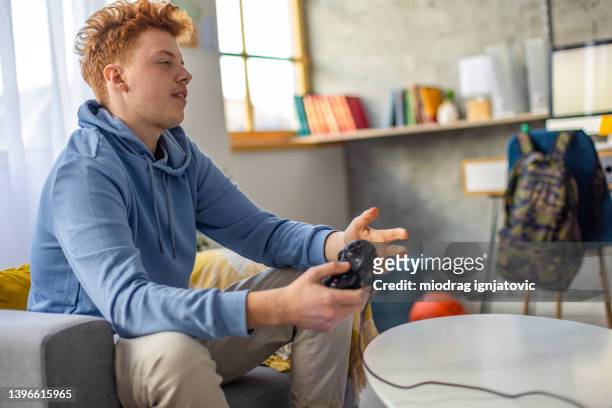 frusrated redhead teenage boy after he lost the game while playing video games - teenage boy playing playstation stock pictures, royalty-free photos & images