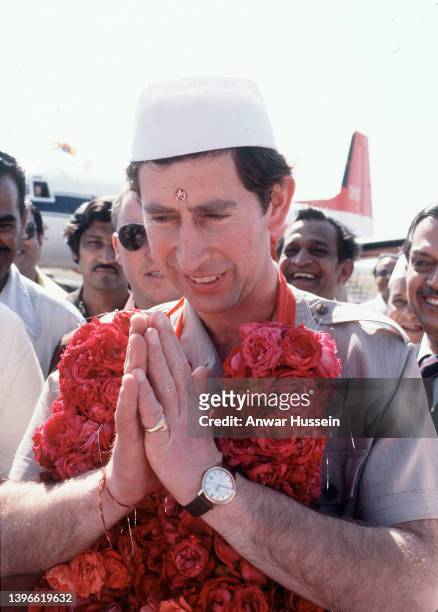 Prince Charles, Prince of Wales wearing a Nehru cap and a garland, arrives at Baroda airport during an official tour of India on November 30, 1980 in...