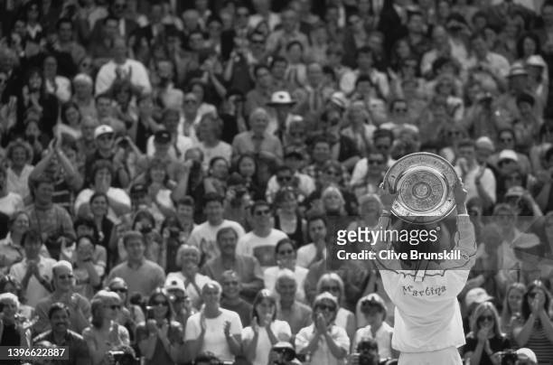 Martina Hingis from Switzerland holds the Venus Rosewater Dish aloft facing towards the crowd of spectators after winning the Women's Singles Final...