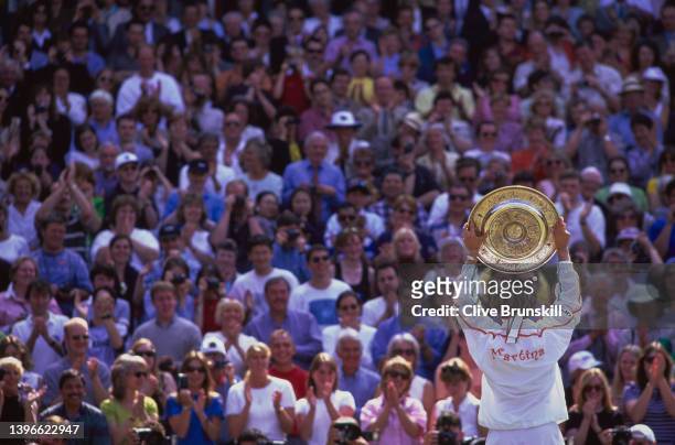 Martina Hingis from Switzerland holds the Venus Rosewater Dish aloft facing towards the crowd of spectators after winning the Women's Singles Final...