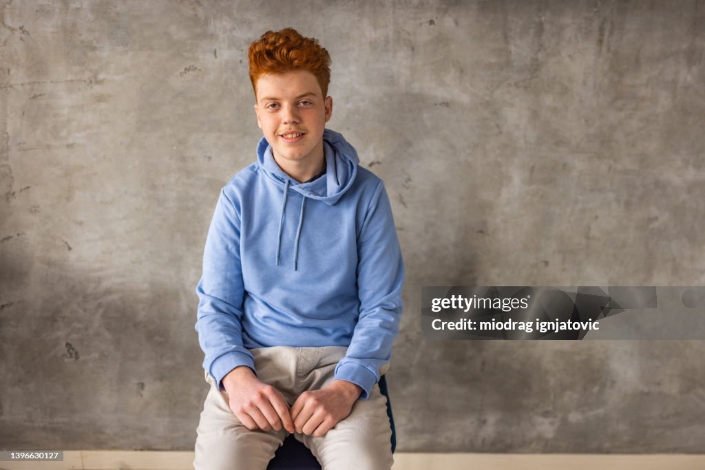 Portrait of confident Caucasian redhead teenage boy with freckles
