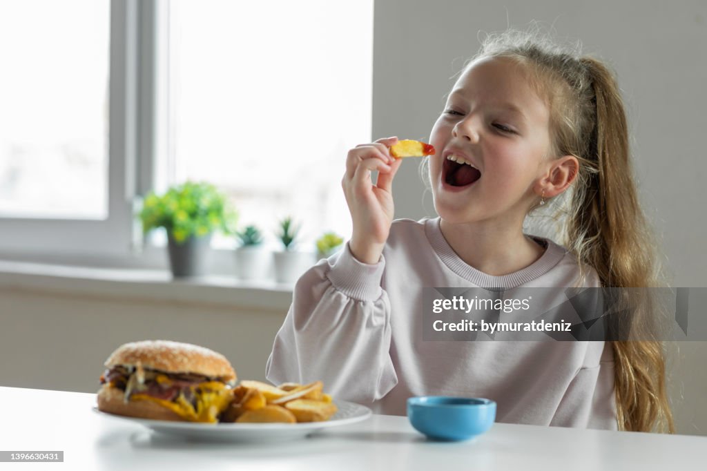 Girl eating french fries with tomato ketchup