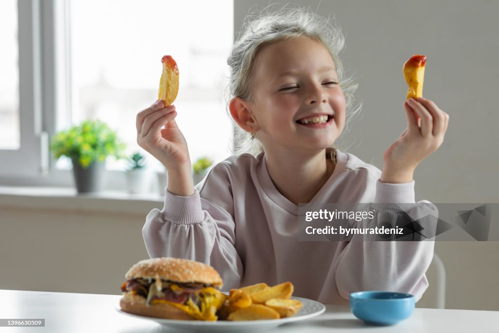 Girl eating french fries with tomato ketchup