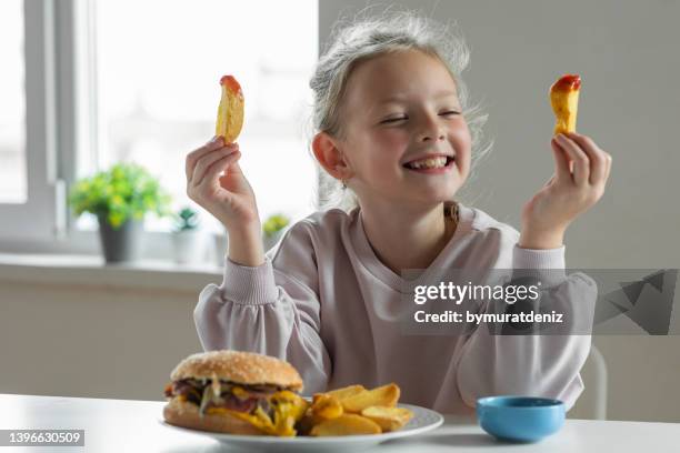 girl eating french fries with tomato ketchup - kid eating burger bildbanksfoton och bilder