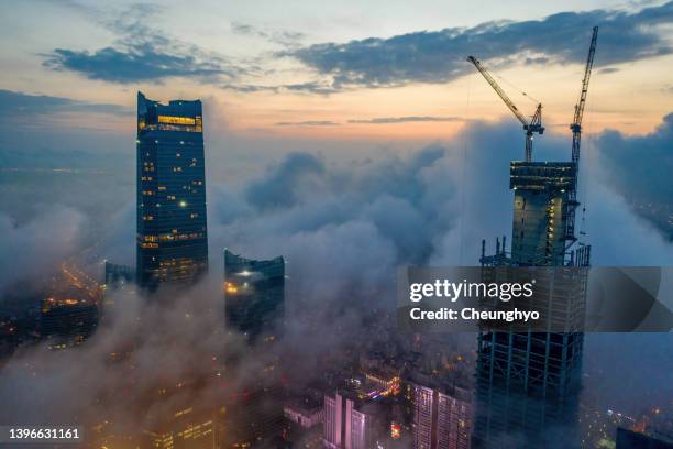 local landmark and construction equipment in the mist, qingdao city, shandong province, china - majestic city stock pictures, royalty-free photos & images