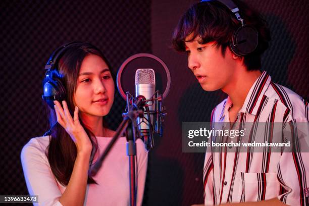 a woman and a man sing in the recording room. - duett bildbanksfoton och bilder