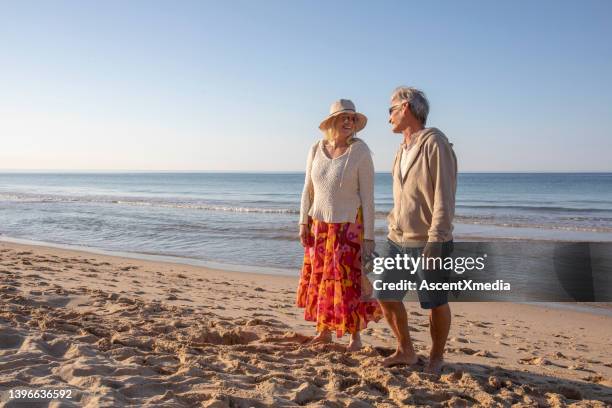 mature couple relax on sandy beach, at sunrise - portugal coast stock pictures, royalty-free photos & images