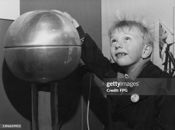 Schoolboy Colin Humphrey makes his hair stand on end with a Van de Graaff generator, at the National Schoolboys Own Exhibition, held at Olympia in...