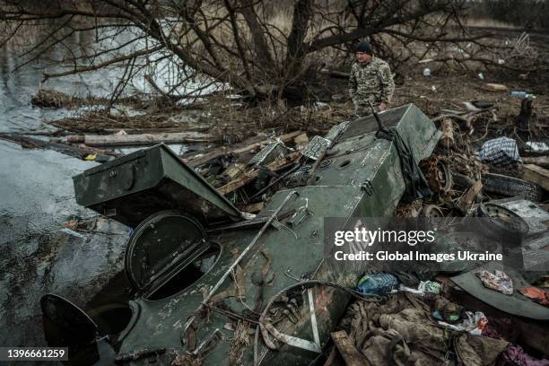 Ukrainian serviceman stands by damaged Russian vehicle marked V on April 8, 2022 in Moshchun, Ukraine. Moshchun village became one of the locations...