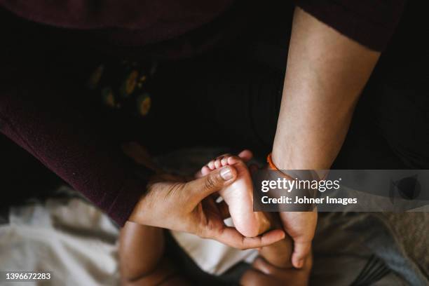 mother massaging baby's foot - maternity leave stockfoto's en -beelden