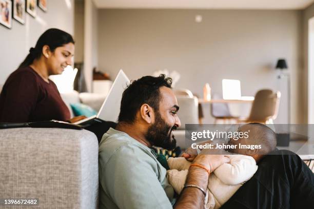 father and mother with baby in living room - south asian people stock pictures, royalty-free photos & images