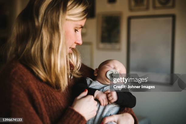 mother holding sleeping newborn baby - baby goods stock pictures, royalty-free photos & images