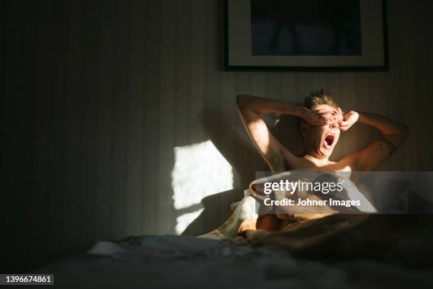 man waking up in bed - ochtend stockfoto's en -beelden